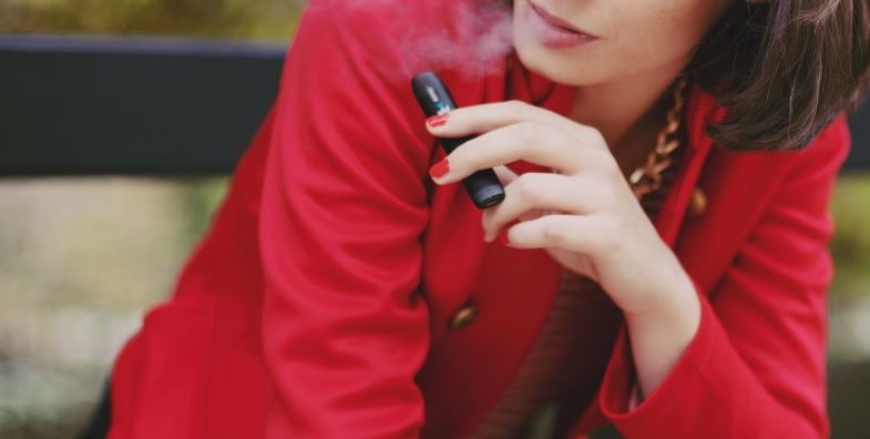 Frau beim Dampfen mit einer kompakten elektronischen Zigarette
