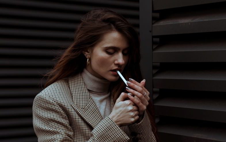 Frau zündet Zigarette an