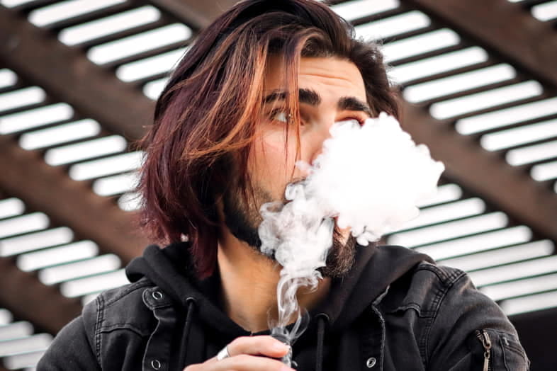 Junge raucht E-Zigarette mit selbst hergestelltem Liquid